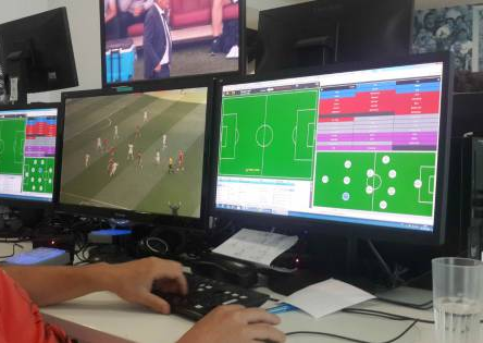 Analista registrando datos durante un partido de fútbol